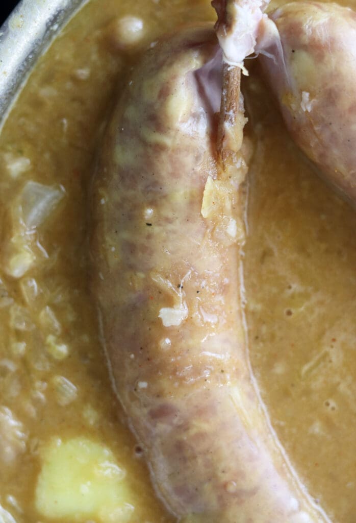 Adding two carniolan sausages to the soup about twelve minutes before the soup is cookes